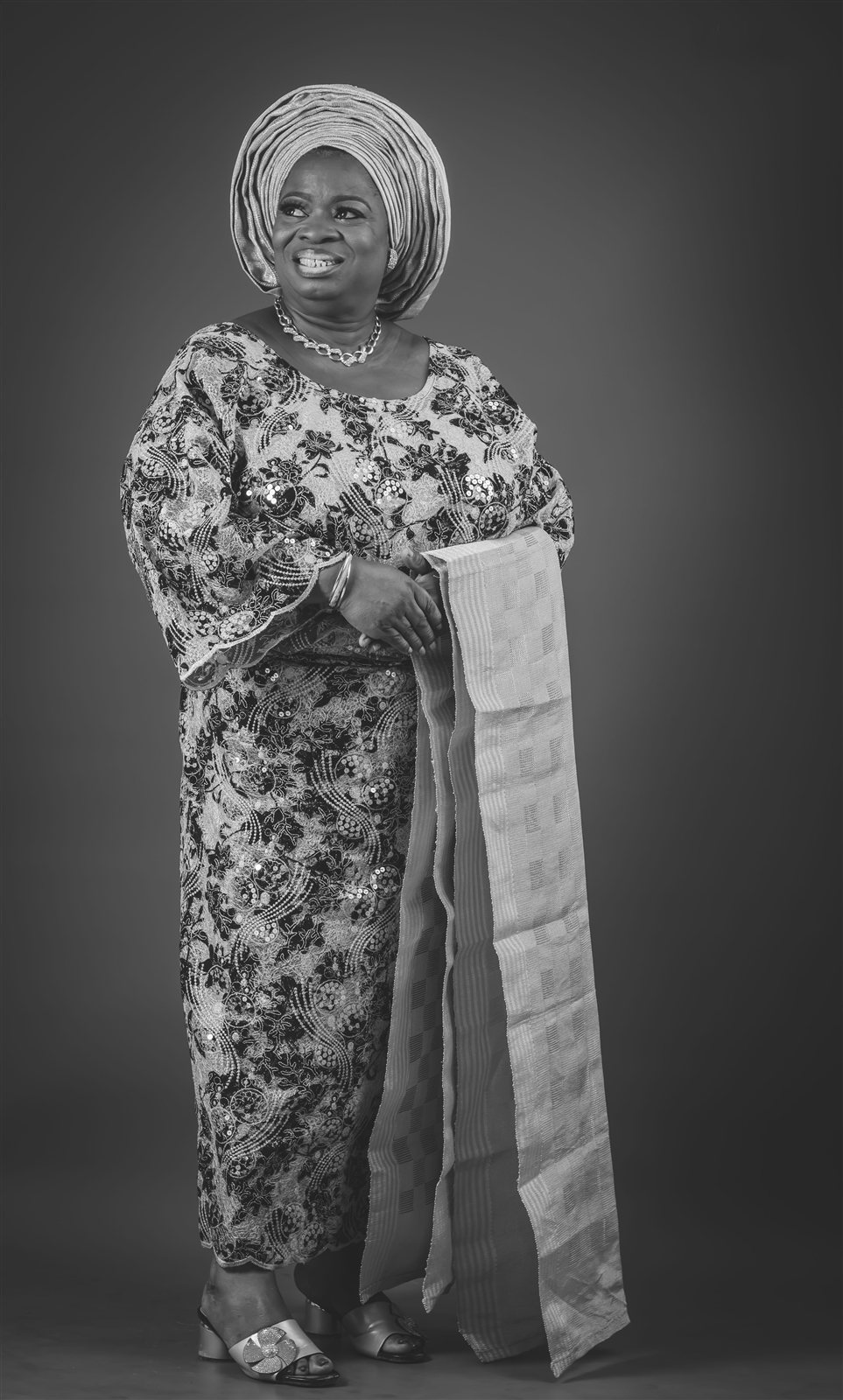 Woman in traditional lace attire and gele, black and white portrait