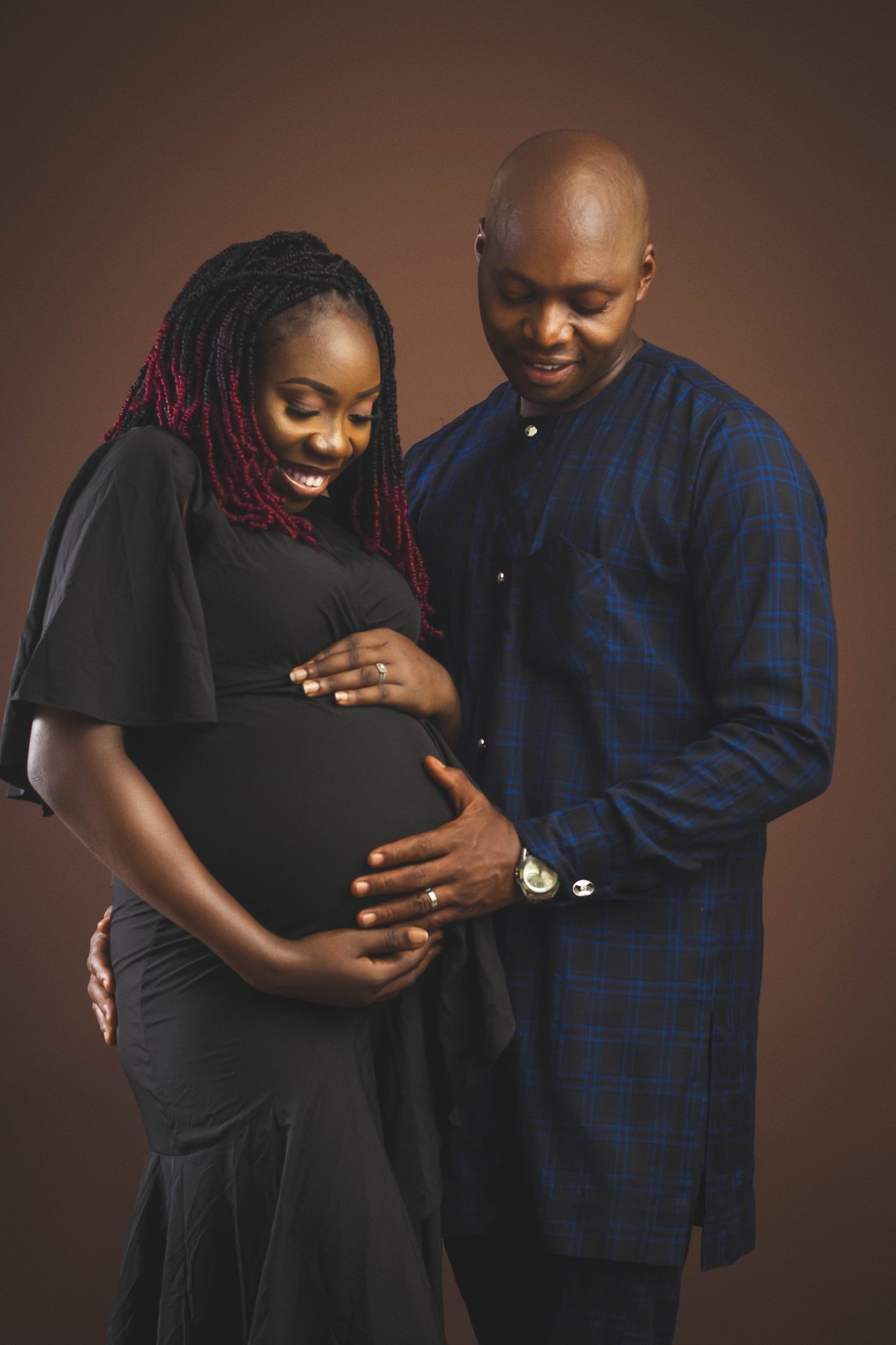 Expectant couple sharing a quiet moment, hands resting on the bump