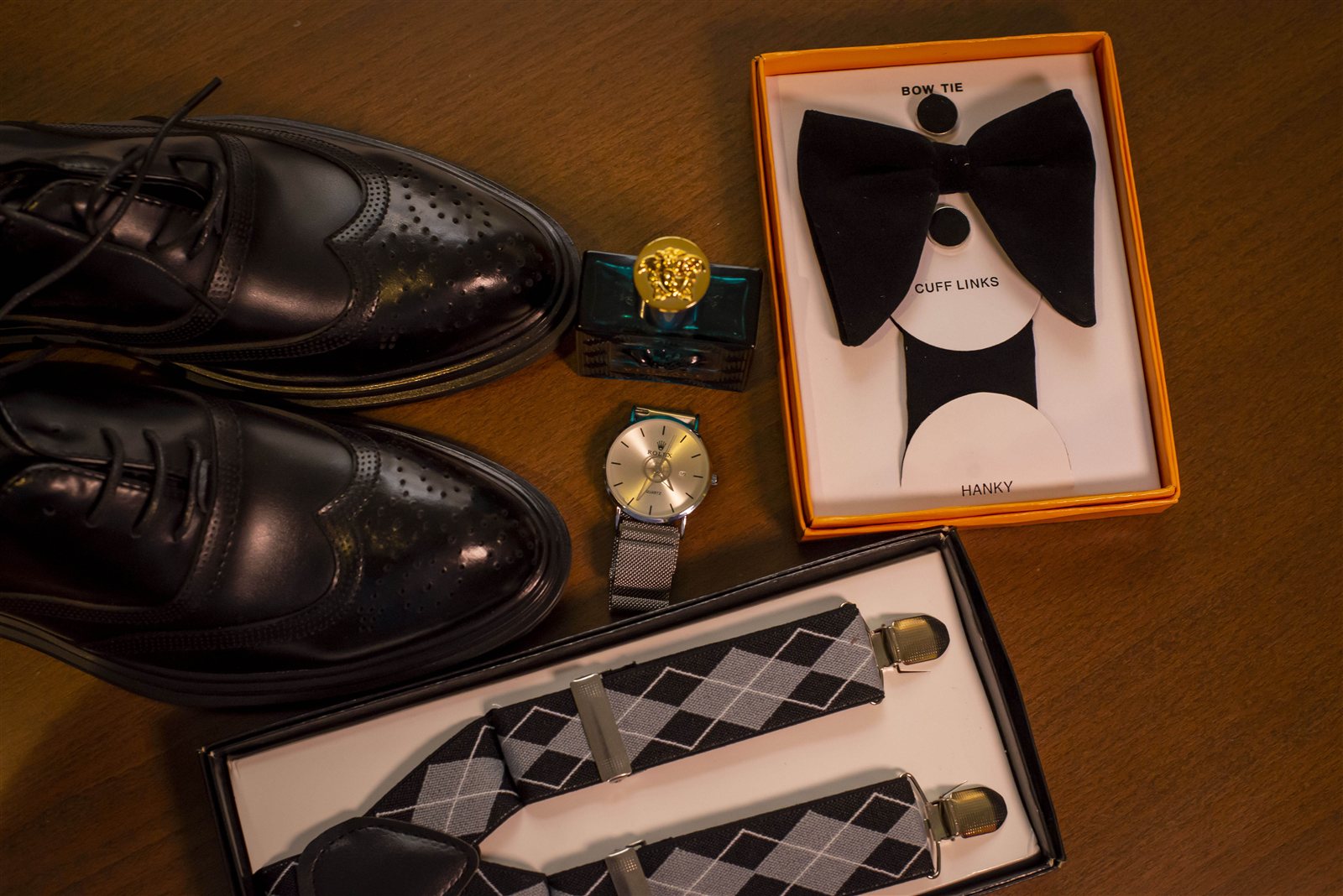 Groom's shoes, watch, cologne, bow tie and suspenders styled flat